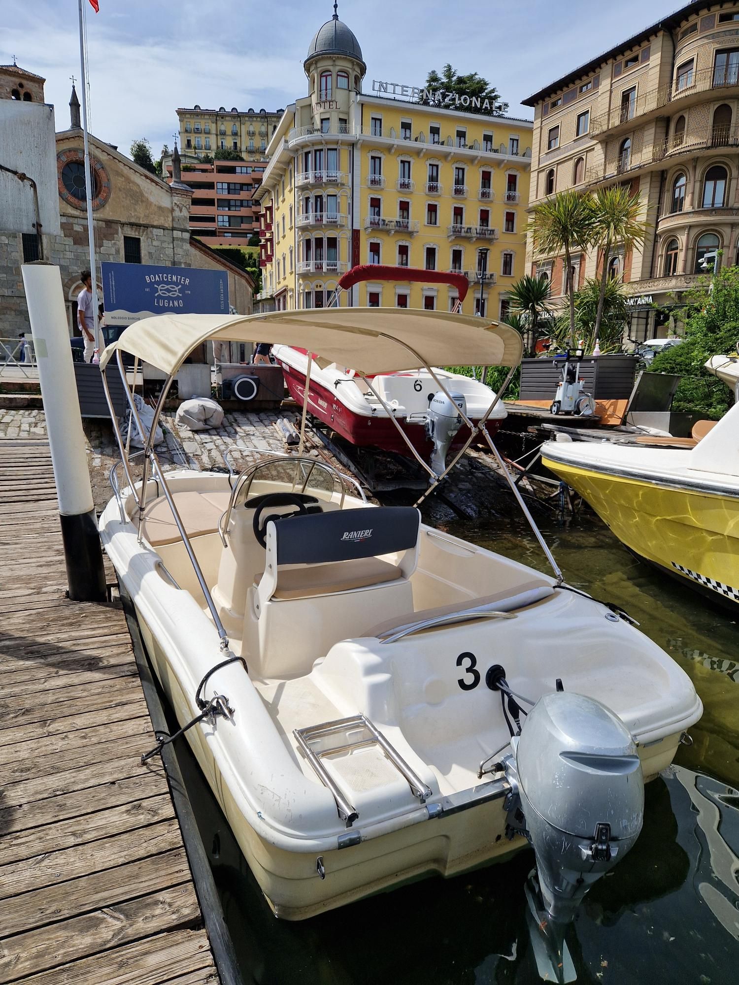 Una barca con il numero 3 è attraccata a un molo.