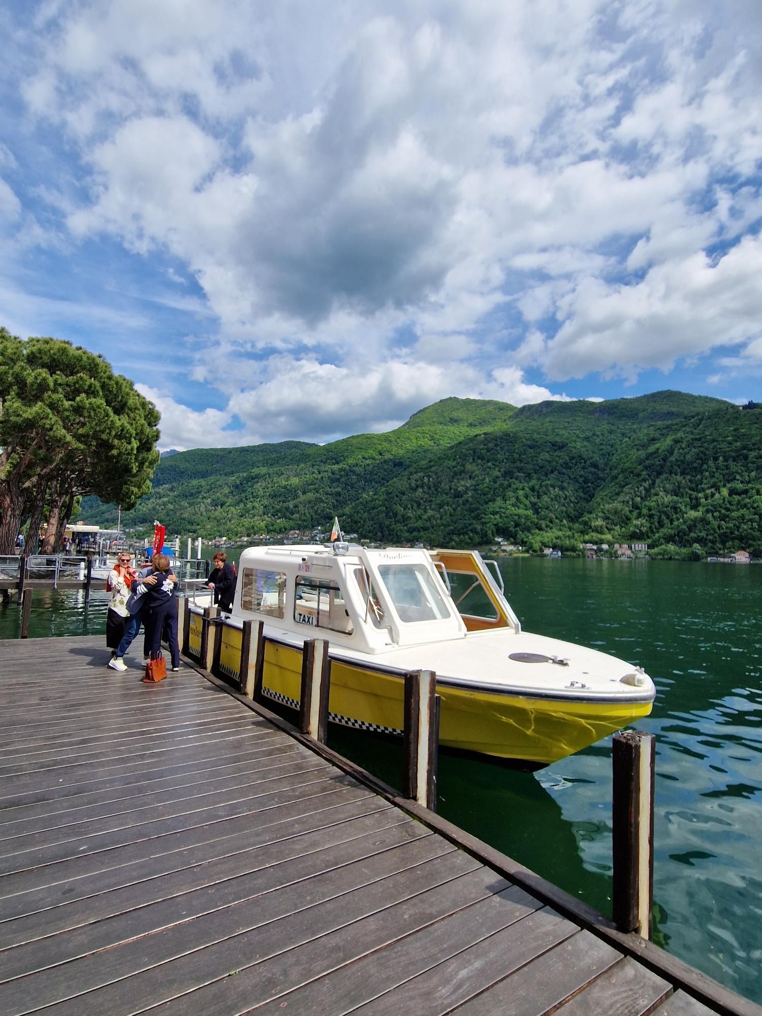 Una barca gialla e bianca è attraccata a un molo su un lago.