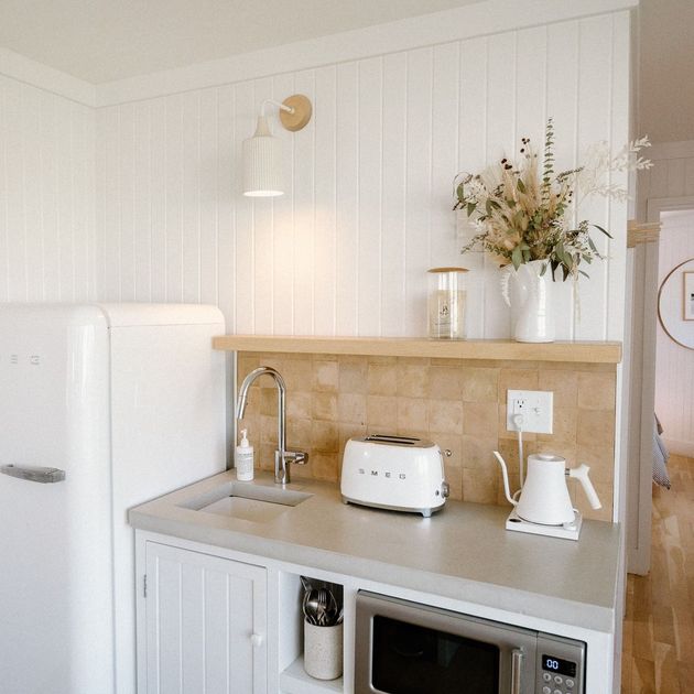 A kitchen with a sink a toaster and a microwave