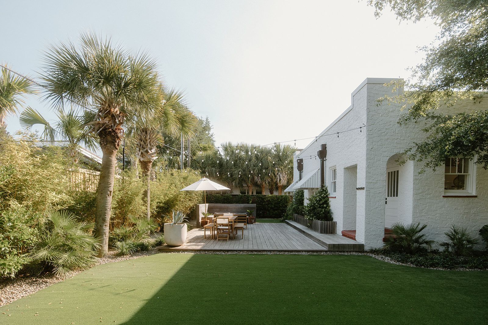 A white house with a large lawn in front of it.