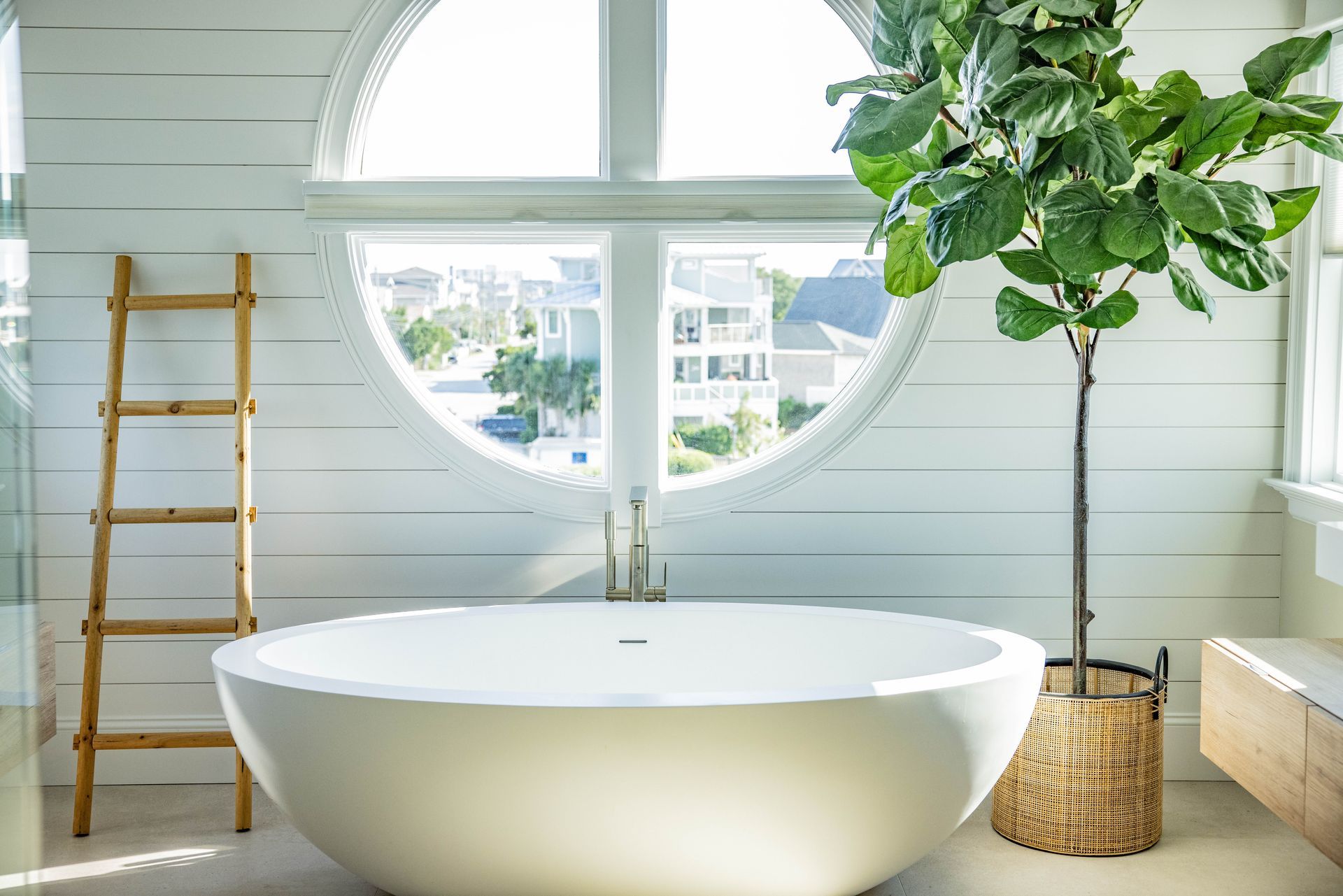 A bathroom with a round window and a bathtub.