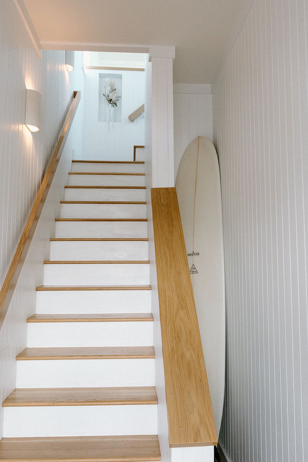 A white staircase with wooden steps and a wooden railing