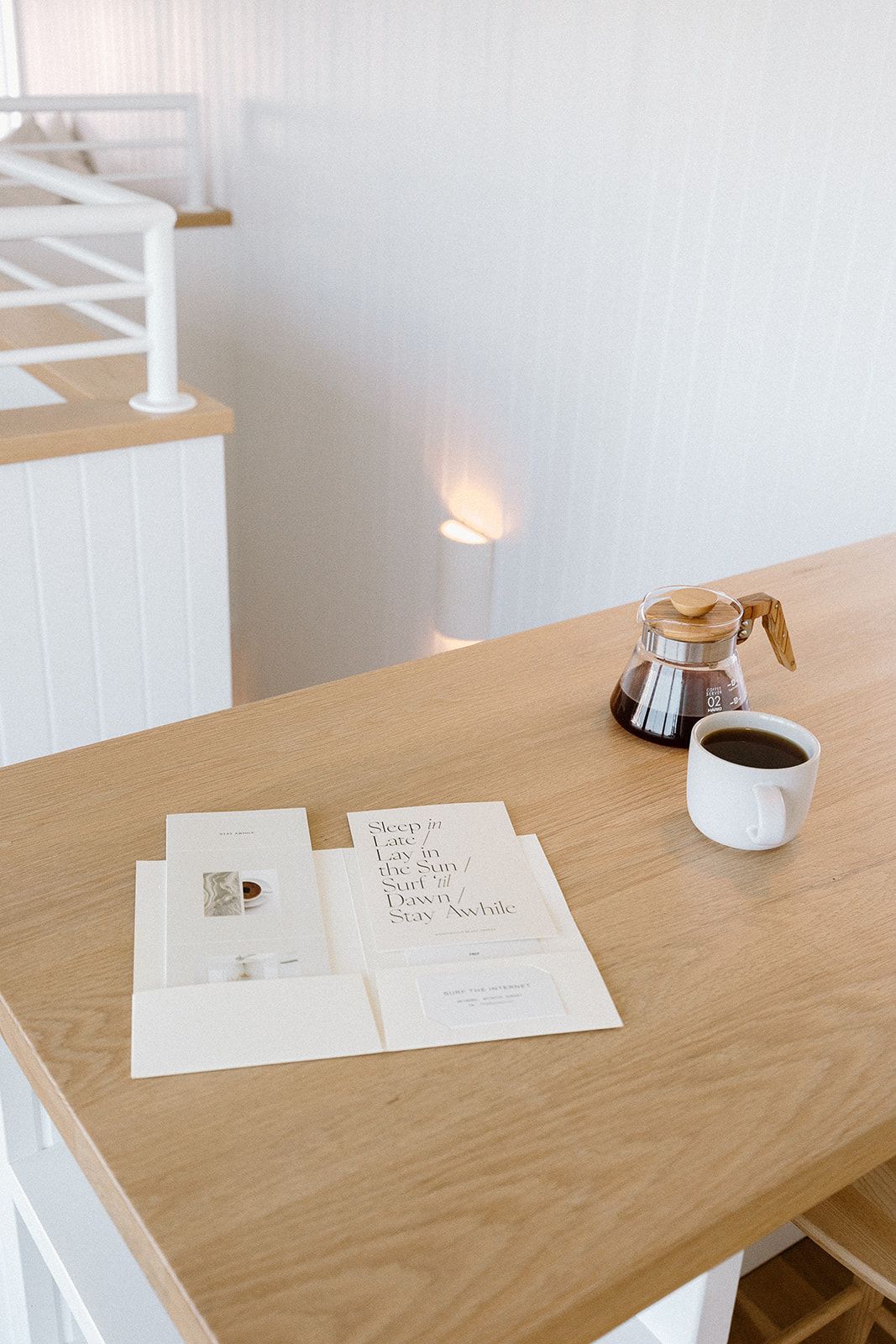 A wooden table with a cup of coffee and a book on it