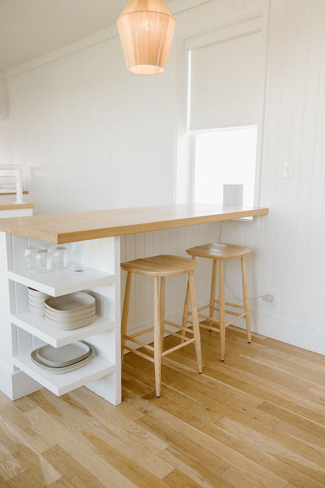 A kitchen with a wooden table and two wooden stools.