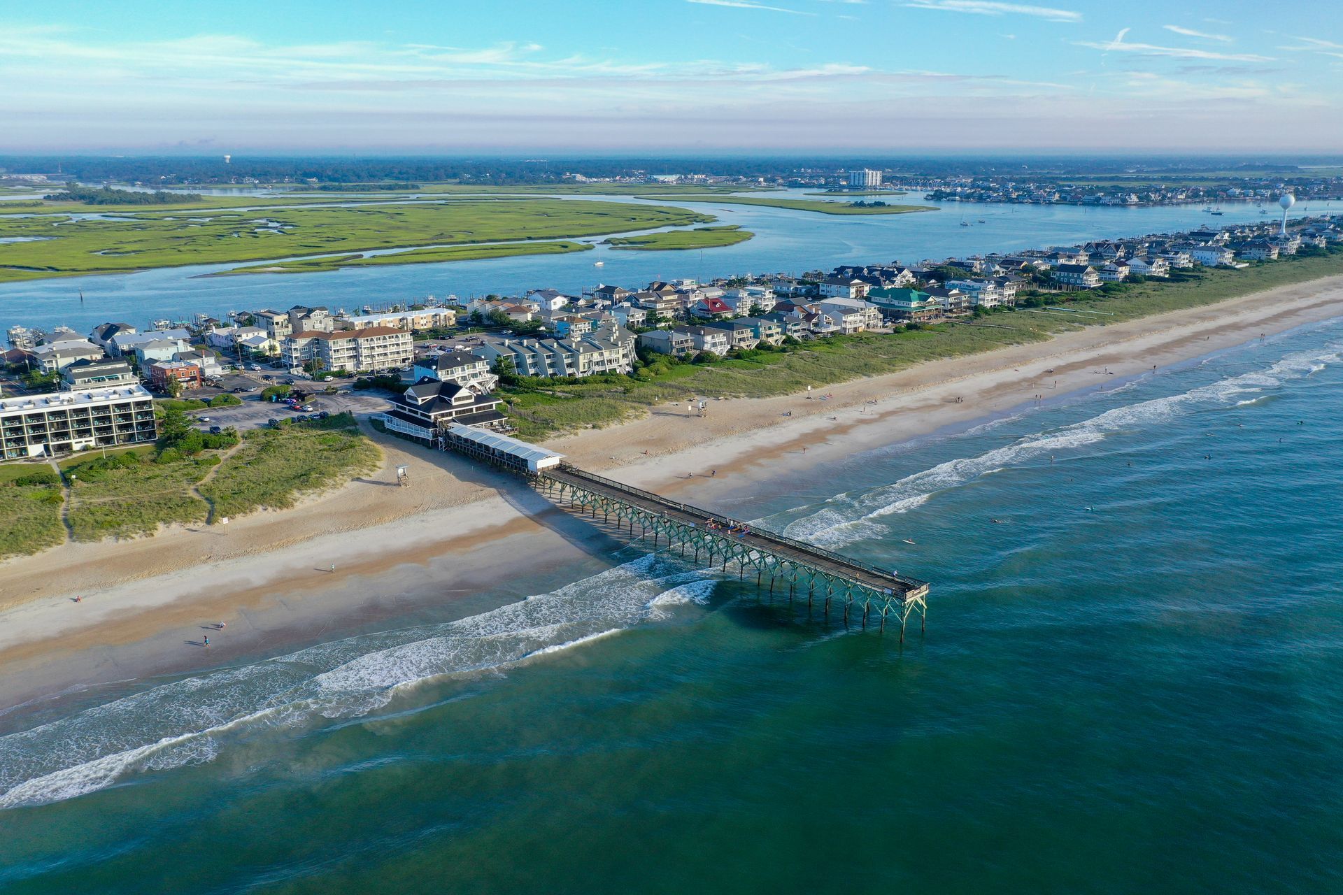 An aerial view of a pier leading to a beach. Mira-Mar Pier.  South End of Wrightsville Beach.