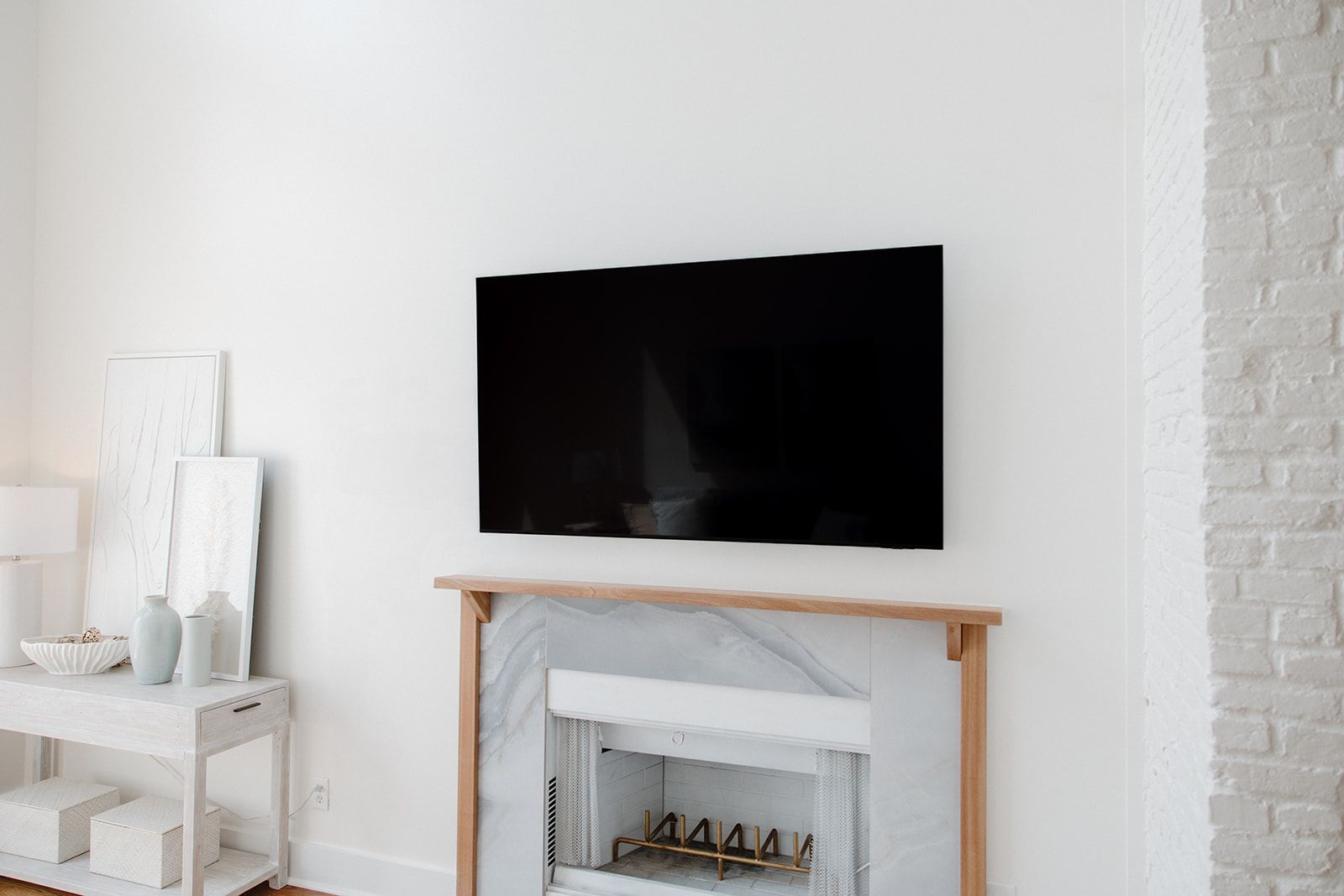 A living room with a fireplace and a flat screen tv on the wall.