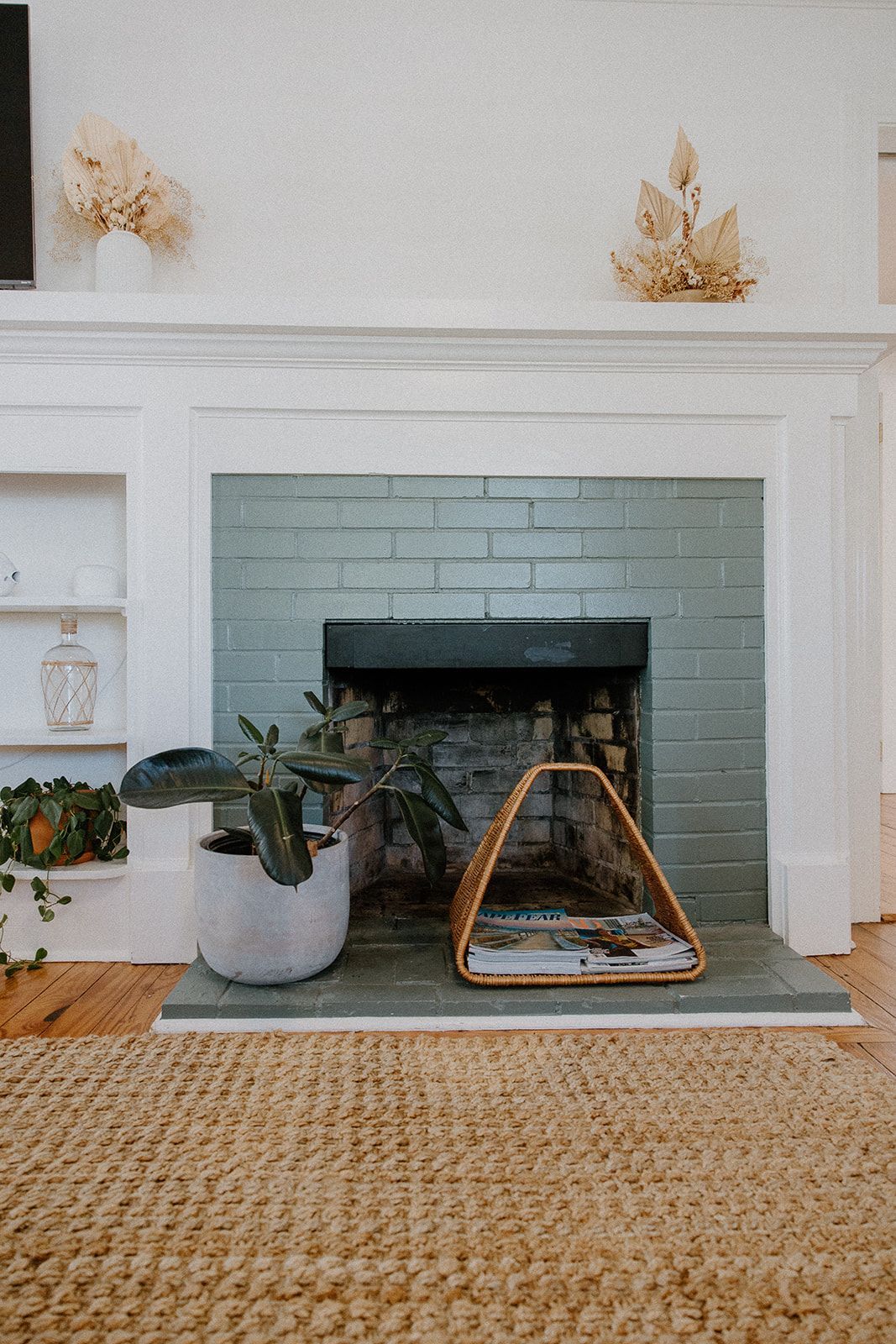 A living room with a fireplace and a rug.
