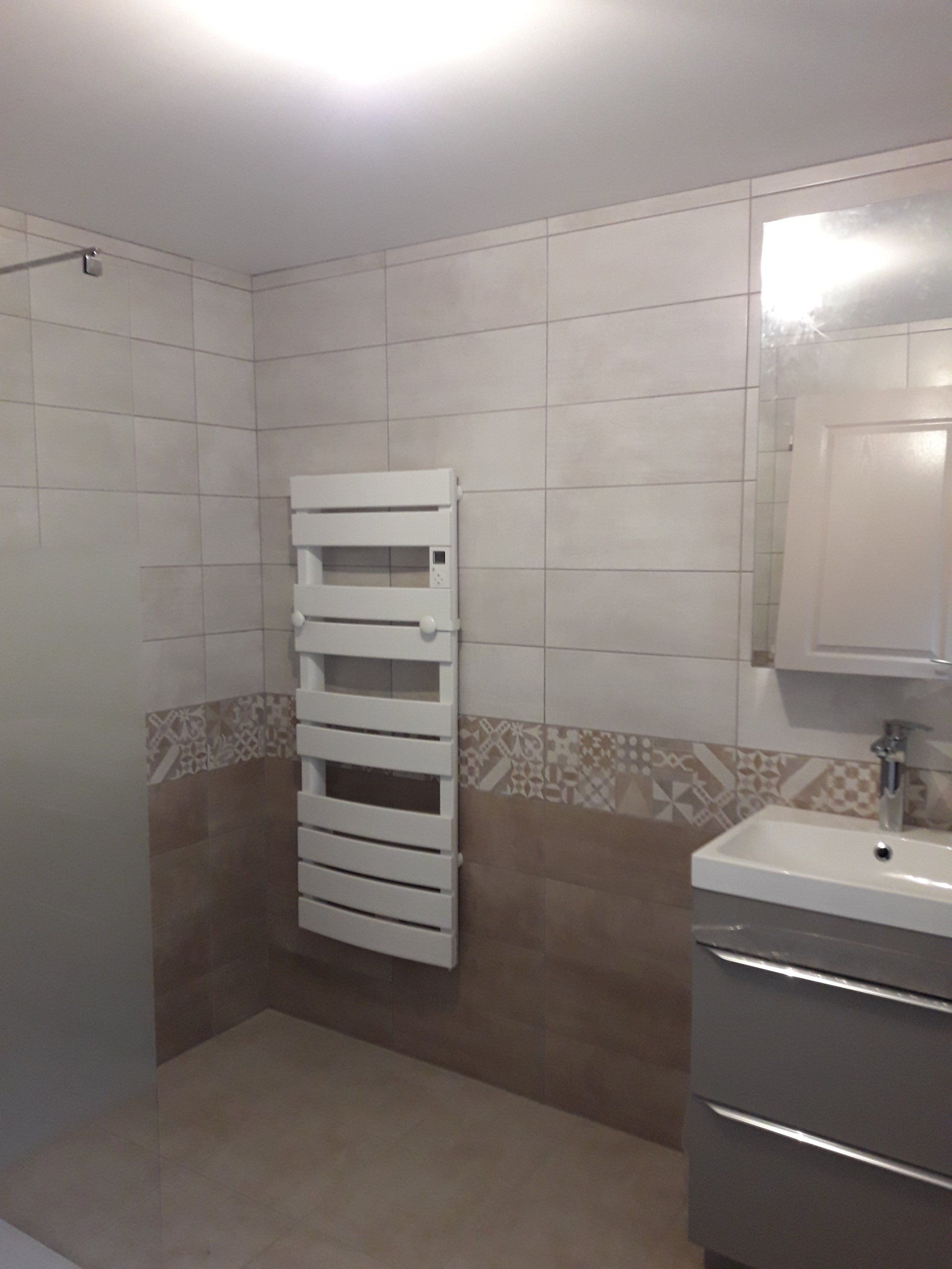 Salle de bains avec carrelage mural bicolore équipée d'un radiateur sèche-serviette