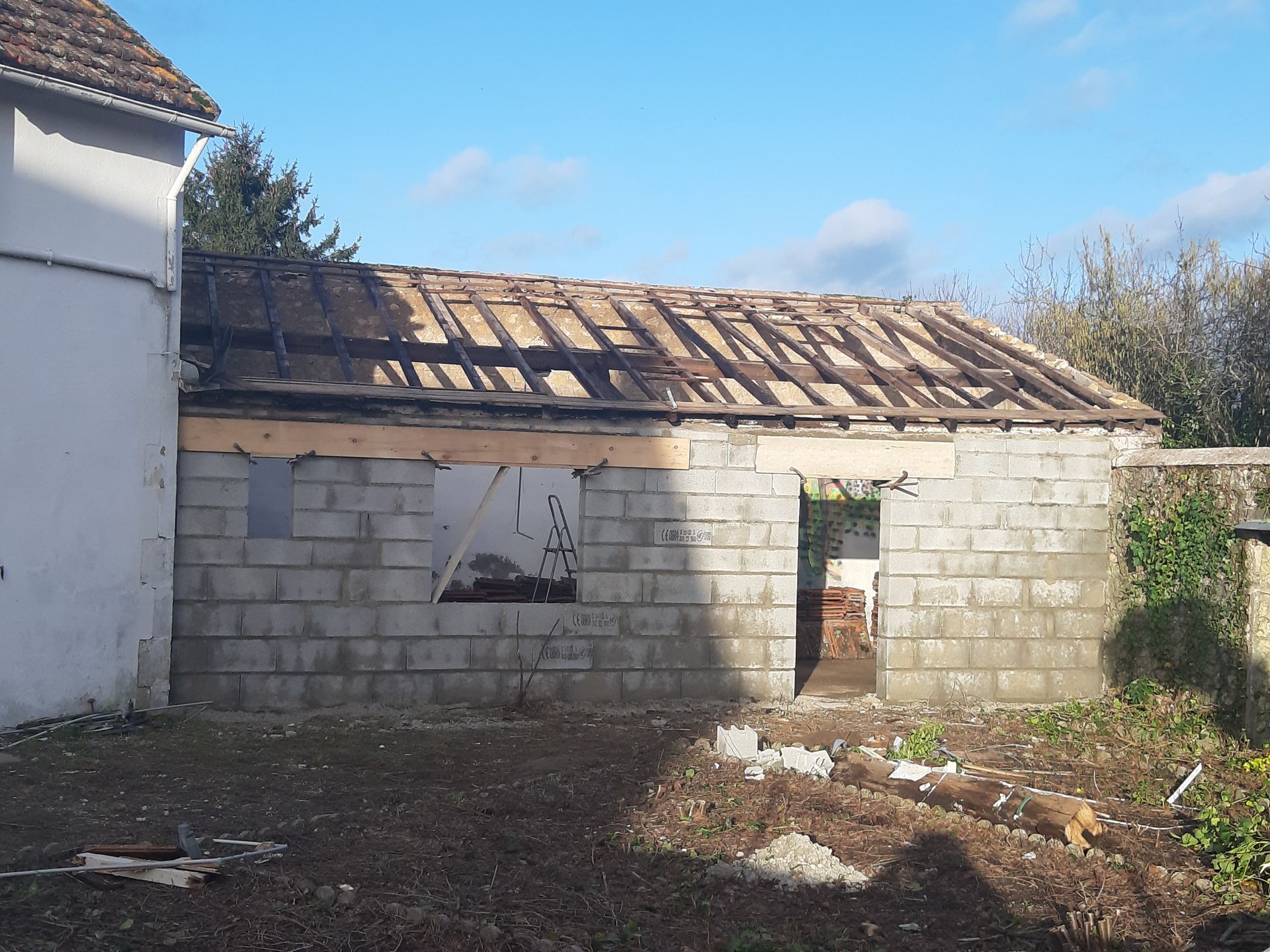 Mur de parpaings finalisé avec ouvertures pour la porte et la fenêtre