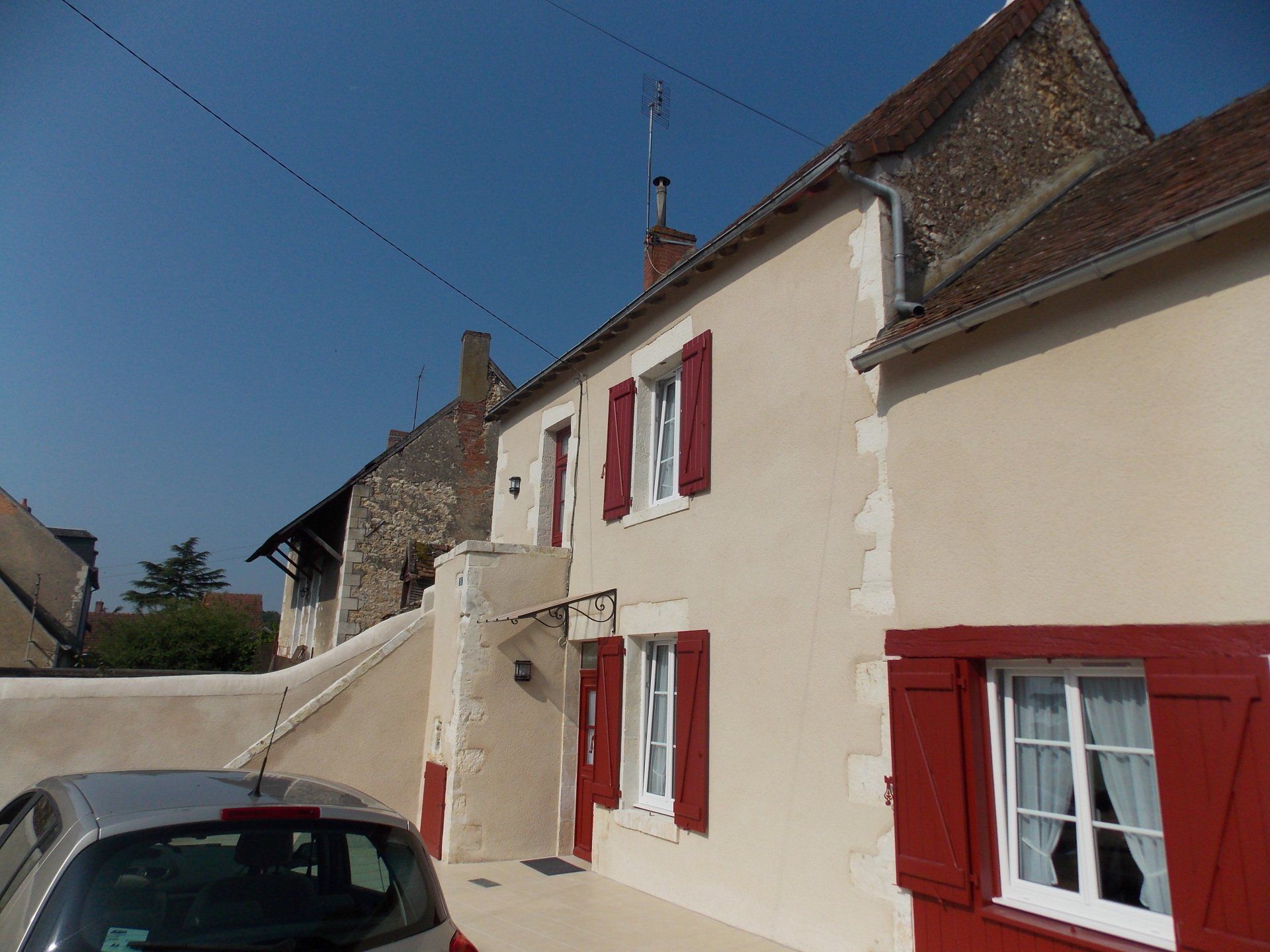 Façade de maison avec volets en bois rouge