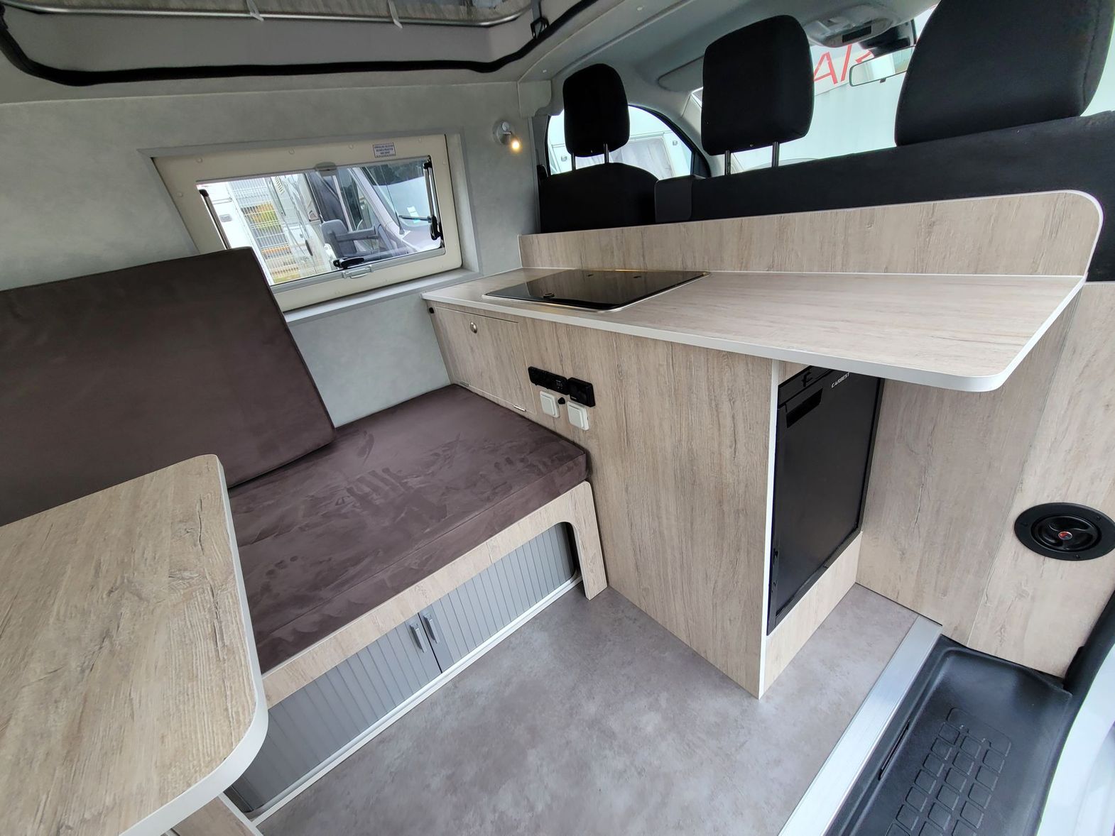 Intérieur d'un van avec une banque et une petite cuisine