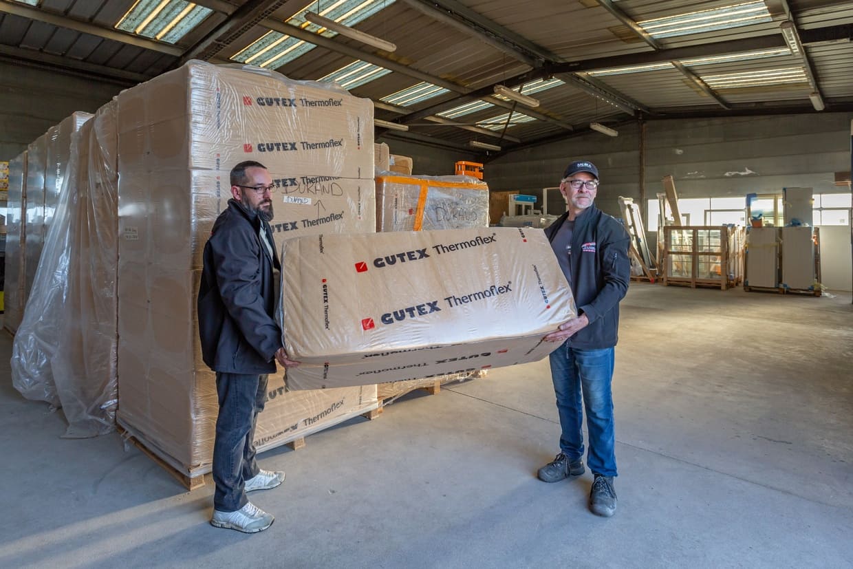 Deux collaborateurs soulevant un produit GUTEX