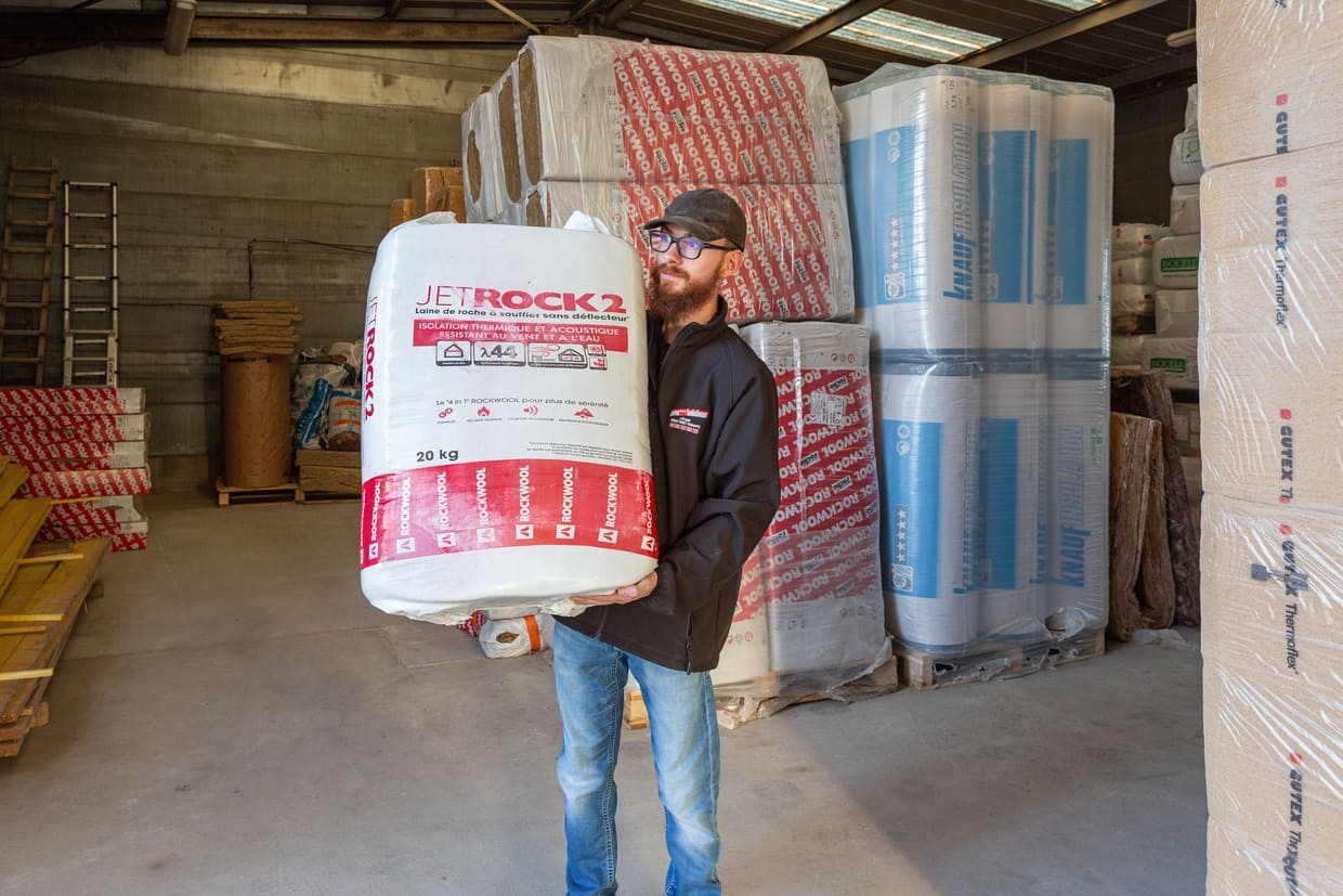 Collaborateur soulevant un produit dans l'entrepôt de l'entreprise