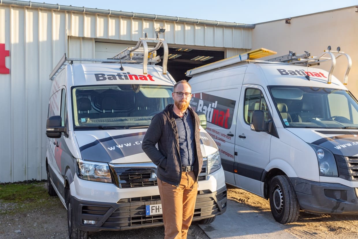 Collaborateur devant les véhicules de Bati'Nat