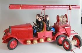 Camion de pompiers rouge miniature avec échelle et petites figurines sur fond blanc