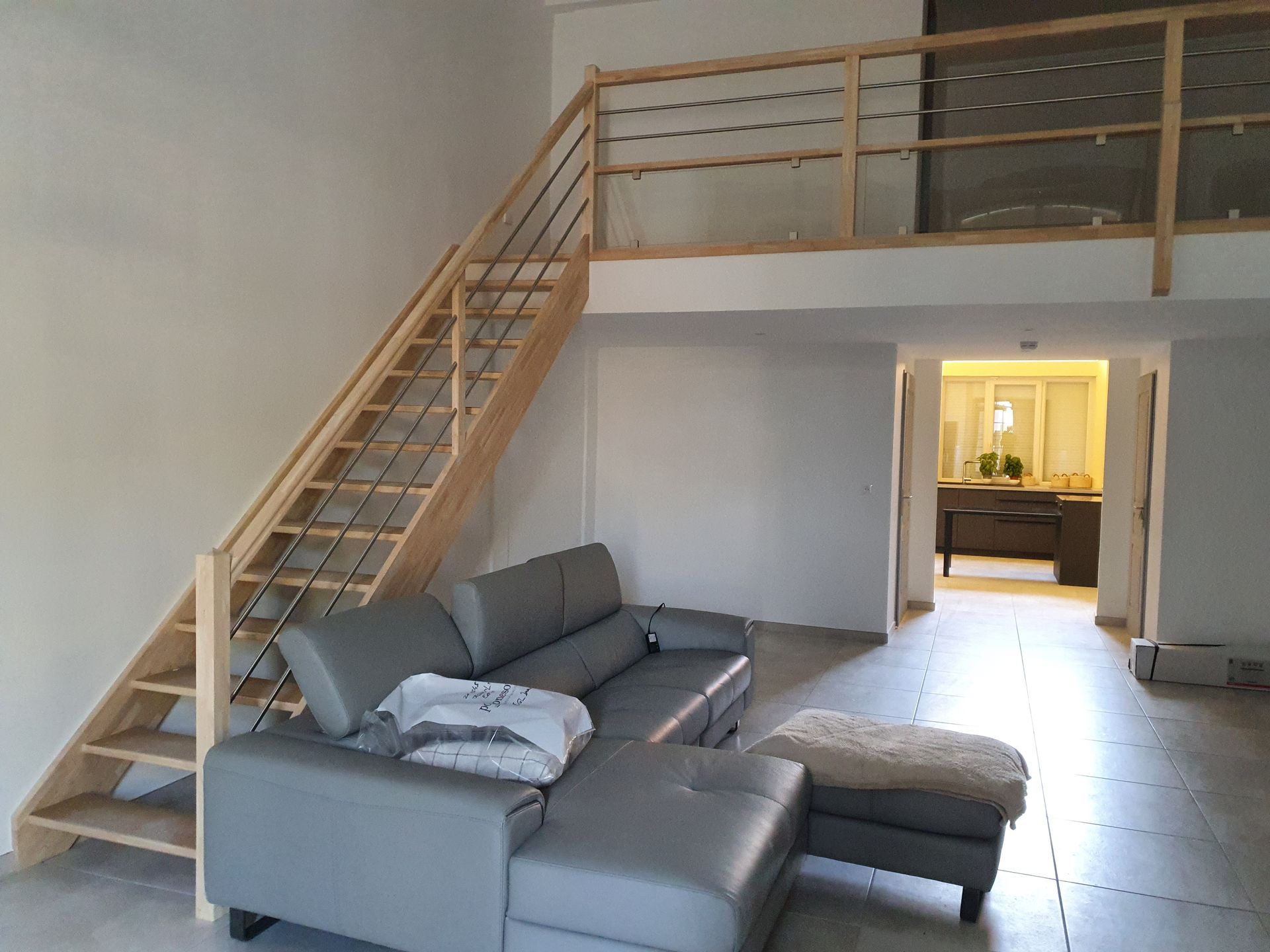 Escaliers mezzanine avec un canapé gris