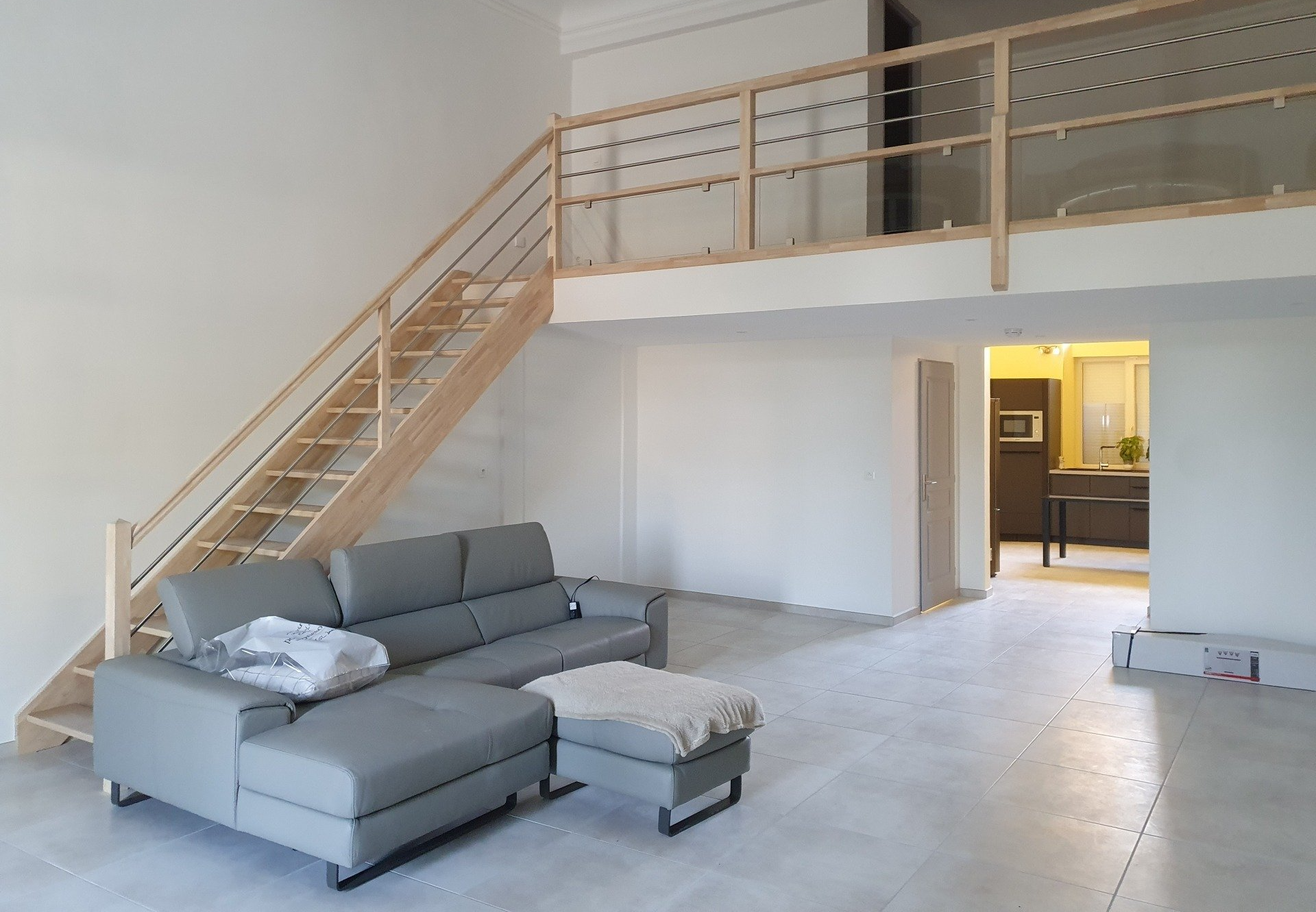 Escaliers avec garde corps en acier et canapé en bas