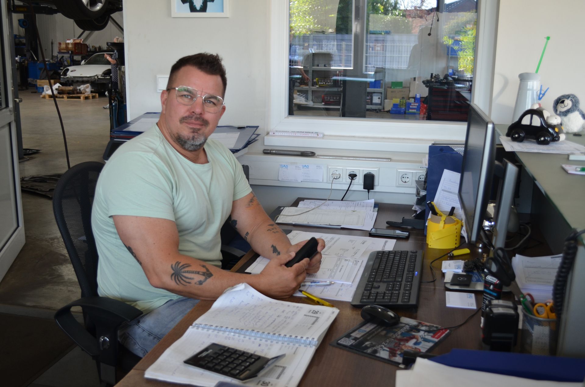 Ein Mann sitzt an einem Schreibtisch vor einem Computer.