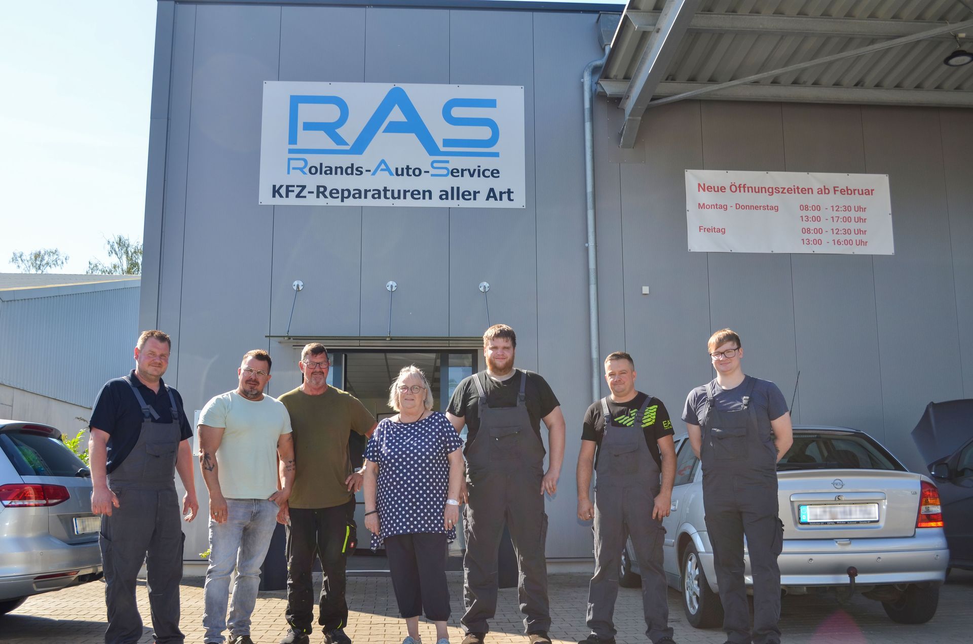 Eine Gruppe von Menschen steht vor einem Gebäude mit der Aufschrift 