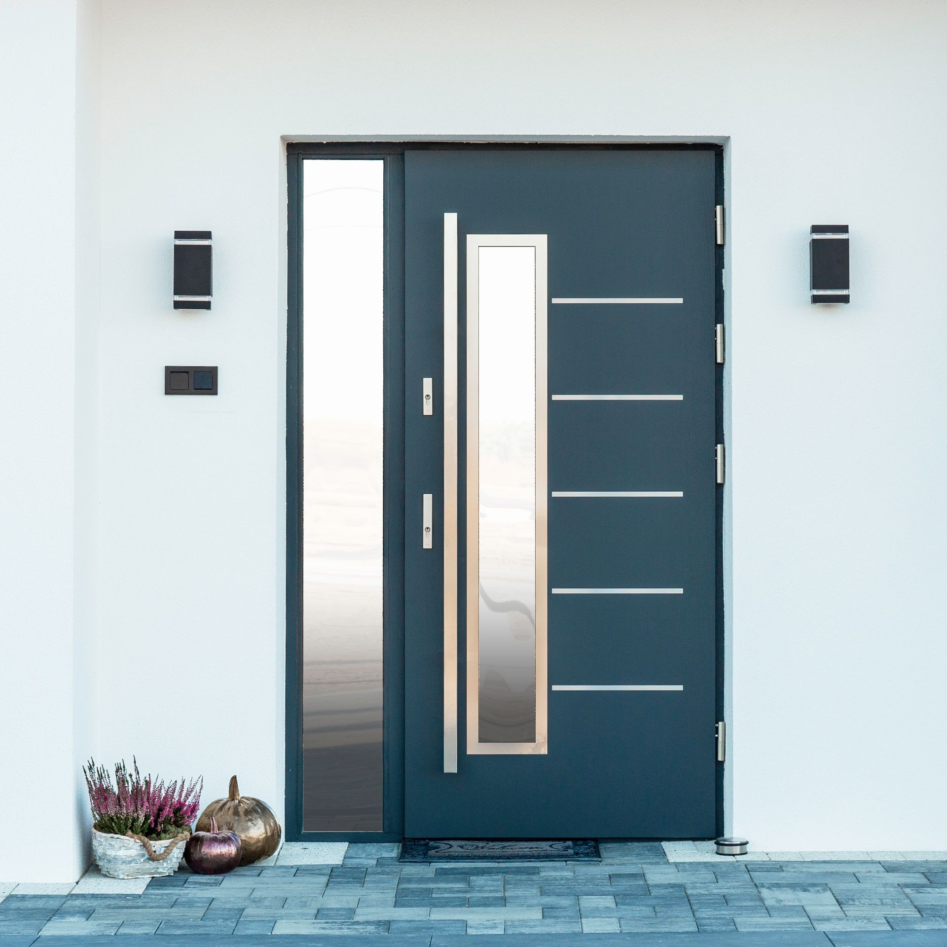 Une porte d'entrée gris anthracite semi-vitrée.