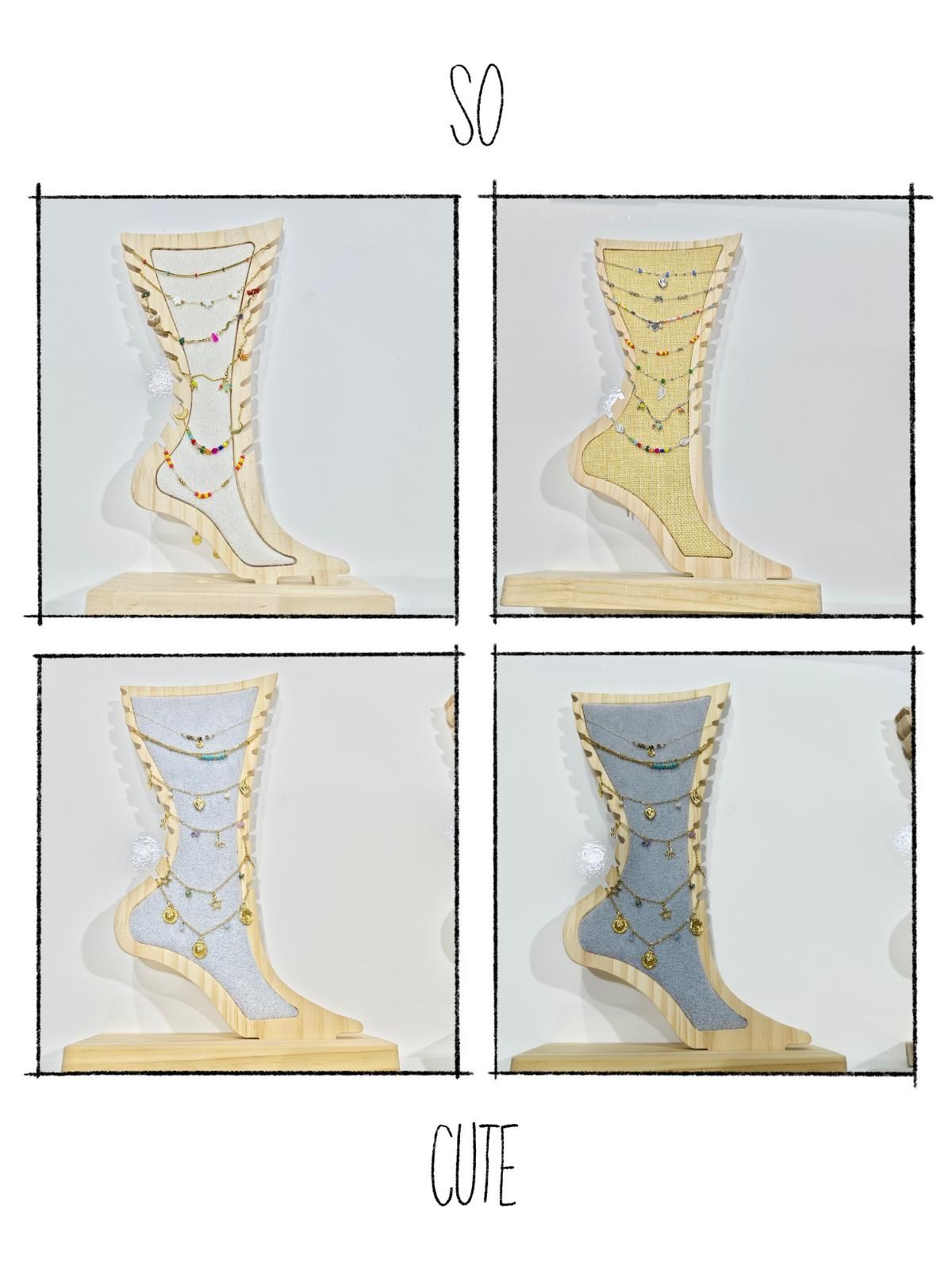 Cuatro esculturas recortadas de piernas y pies, cada una con superficies de diferentes colores (crema, amarillo, plata, azul) sobre bases de madera, etiquetadas como 