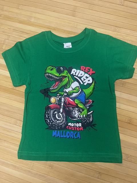 Camiseta verde con un dinosaurio de dibujos animados en moto. El texto dice 