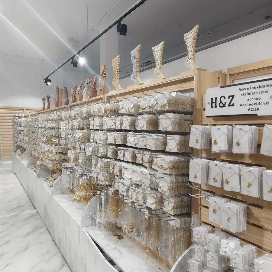 Exhibición de joyas en la tienda H&Z, con muchos aretes y collares empaquetados. Estantes de madera.