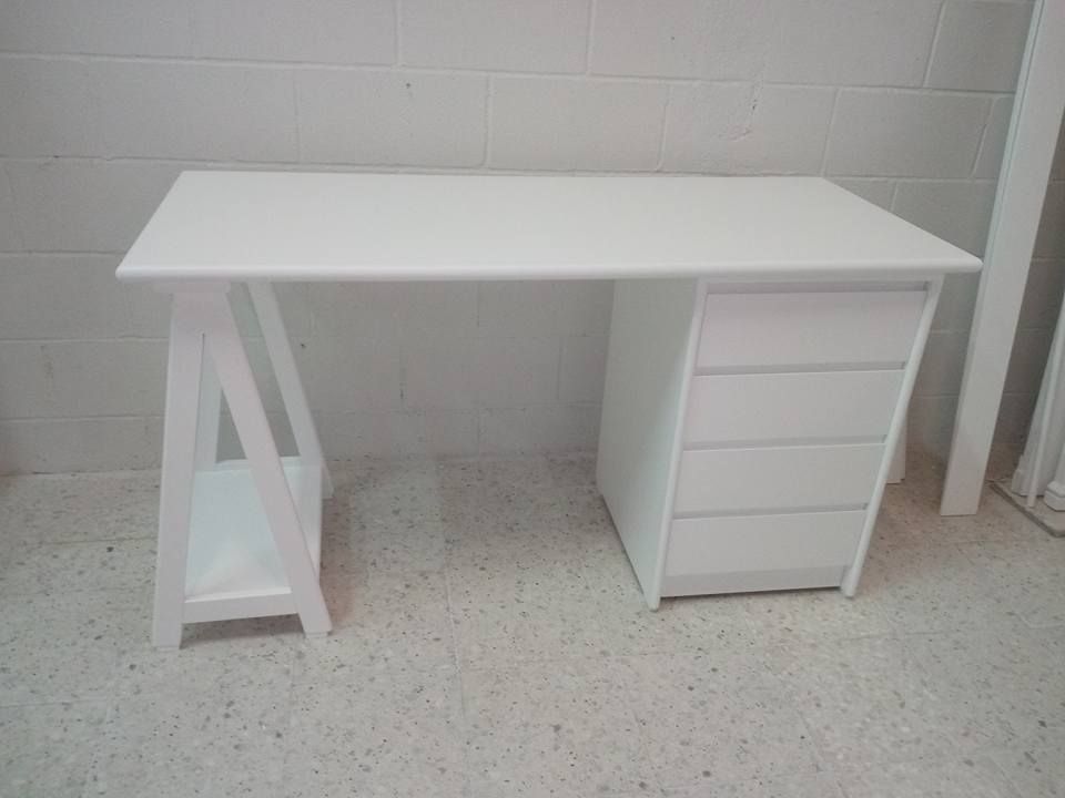 Un escritorio blanco con cajones y un estante está en una habitación.