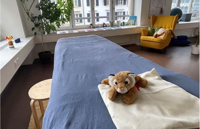 Ein Stofftier liegt auf einem Bett in einem Zimmer.