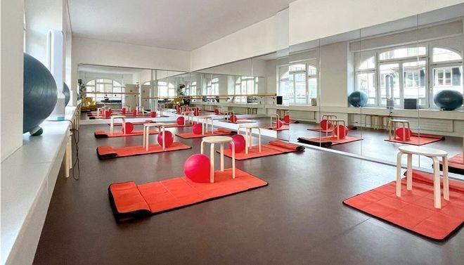 Ein Fitnessstudio mit vielen Matten und Bällen auf dem Boden