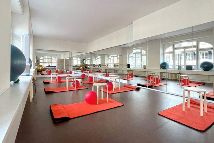 Ein Fitnessstudio mit vielen Matten und Bällen auf dem Boden
