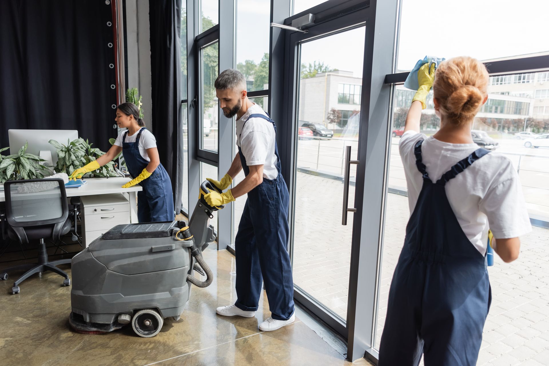 Un homme passe la machine pour récurer le sol dans un bureau