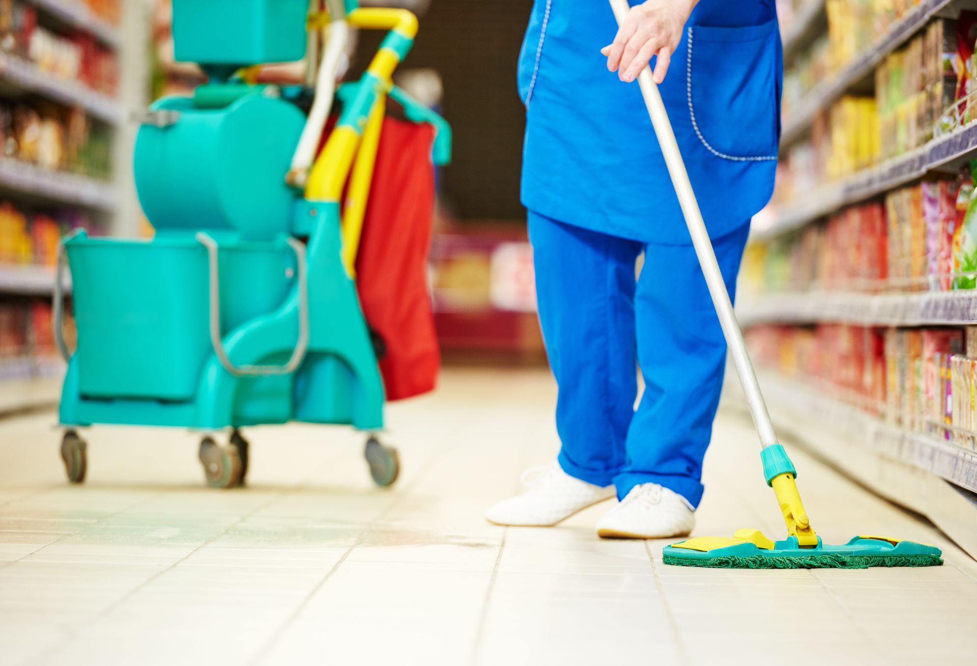 Femme qui passe la serpillière dans un magasin