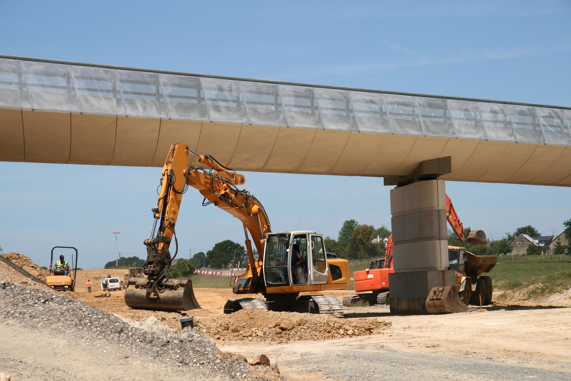 Travaux avec une pelleteuse pour construction de route sous un pont