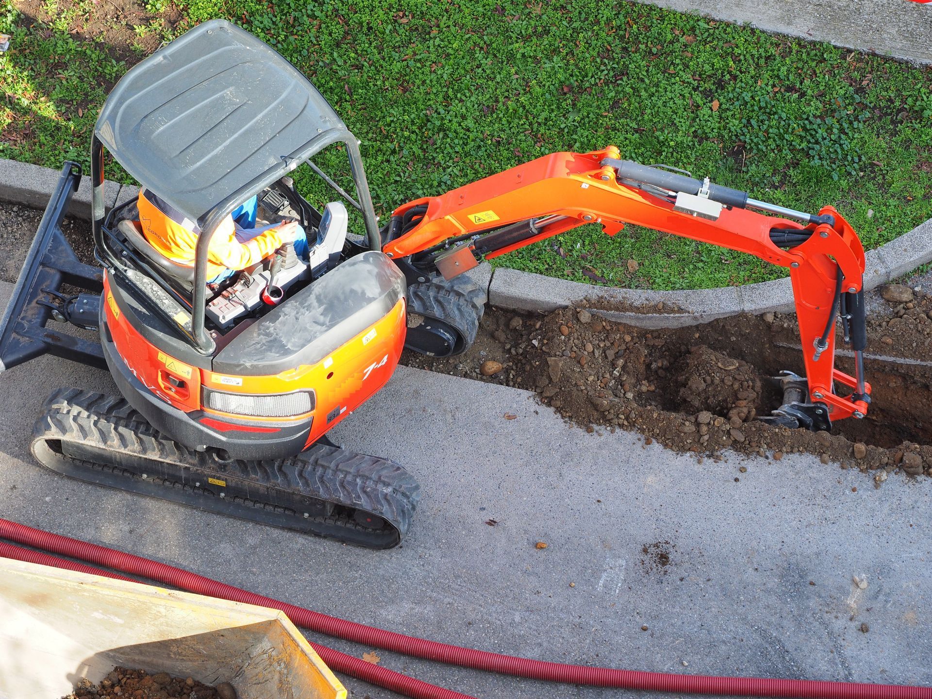 Une pelleteuse orange qui creuse une tranchée