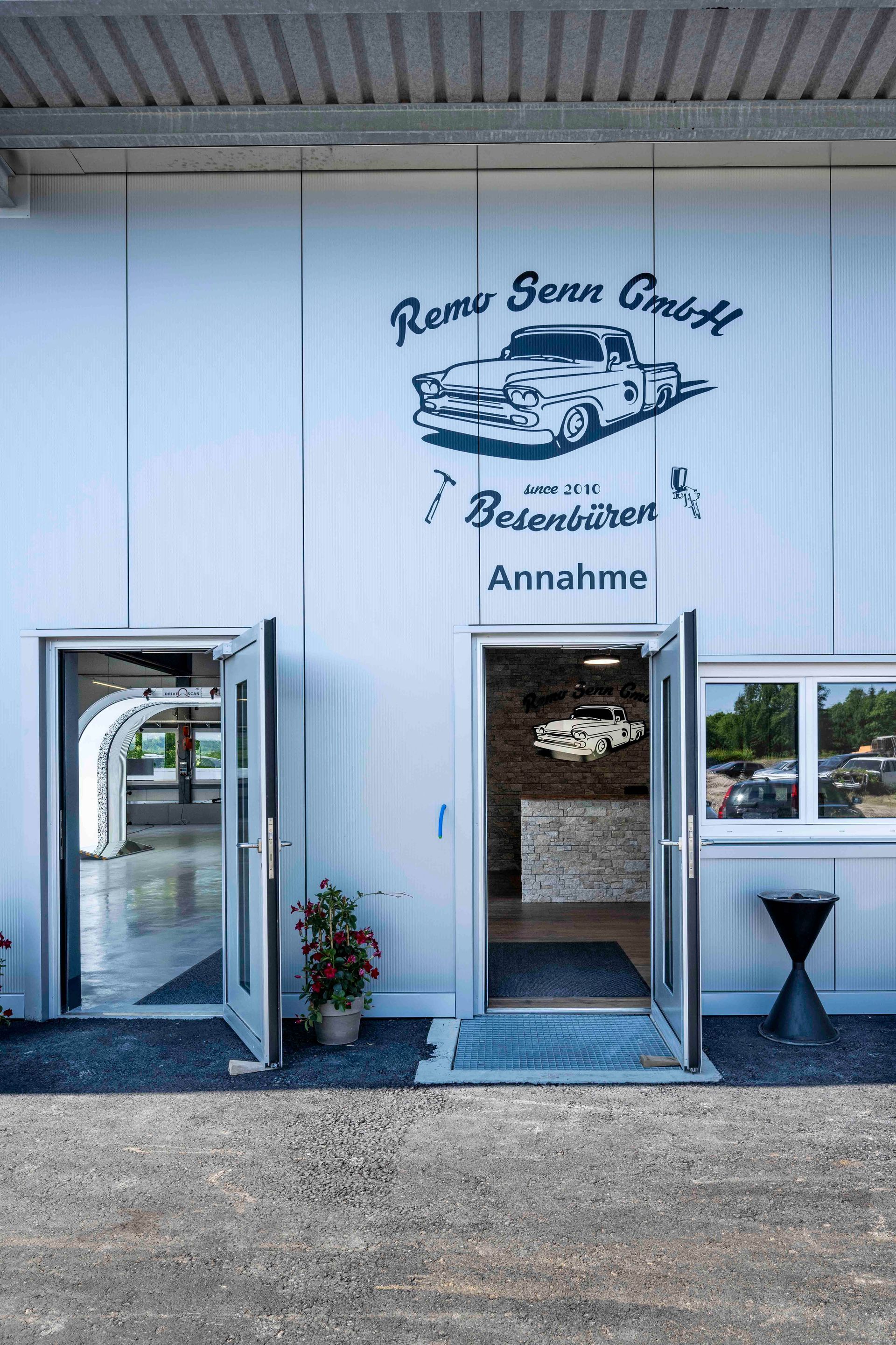 Außenansicht des Gebäudes der „Renn Senn GmbH“ mit offenen Türen und einem Autologo.