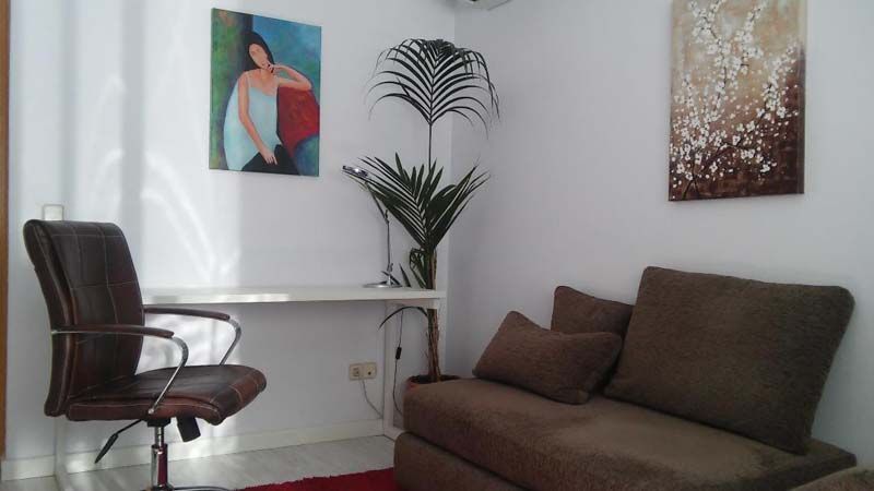 Una sala de estar con un sofá, un escritorio y una silla.