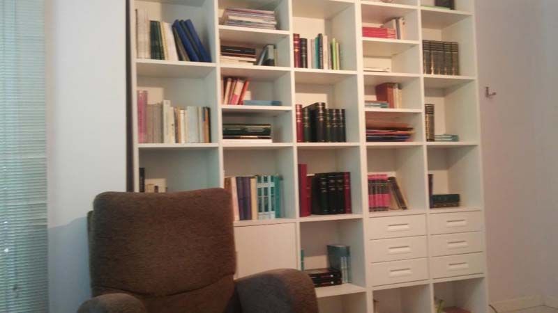 Una silla está delante de una estantería llena de libros.