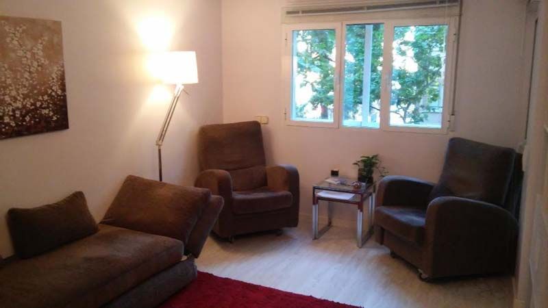 Una sala de estar con un sofá y dos sillas.