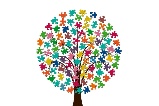 Un árbol hecho con piezas de rompecabezas sobre un fondo blanco.