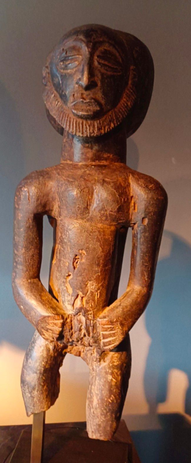 Statuette d'une personne avec les mains attachées devant