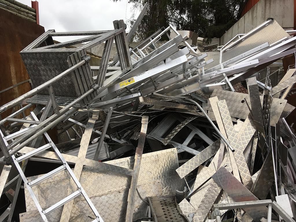 Tas de ferraille, comprenant des échelles et des panneaux.