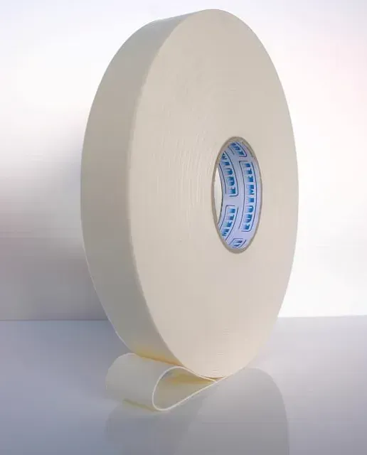Un rollo de cinta blanca está sobre una superficie blanca.