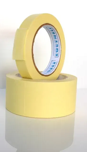 Dos rollos de cinta amarilla están apilados uno encima del otro sobre una mesa.