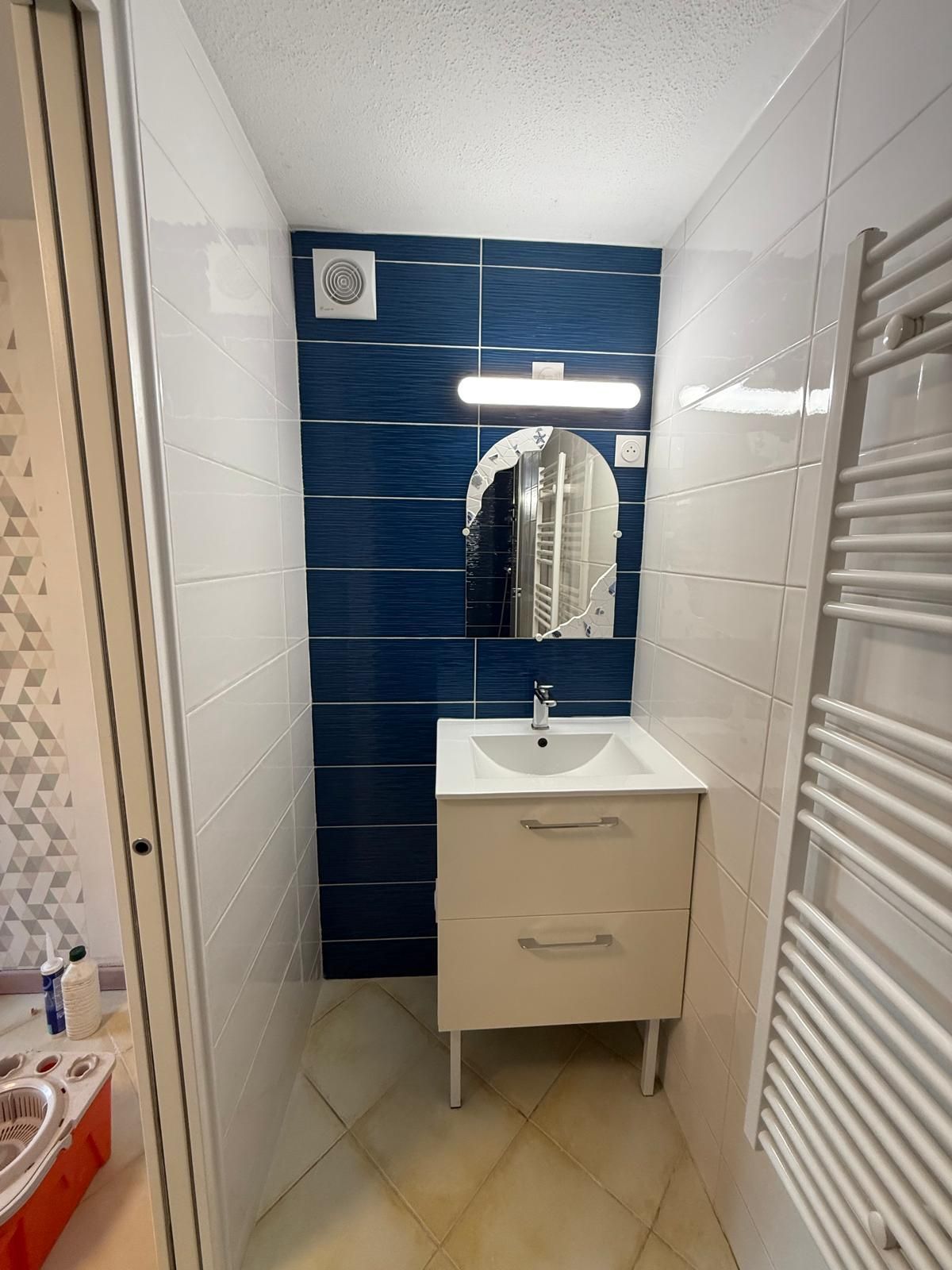 Meuble de salle de bain à côté d'un sèche-serviettes