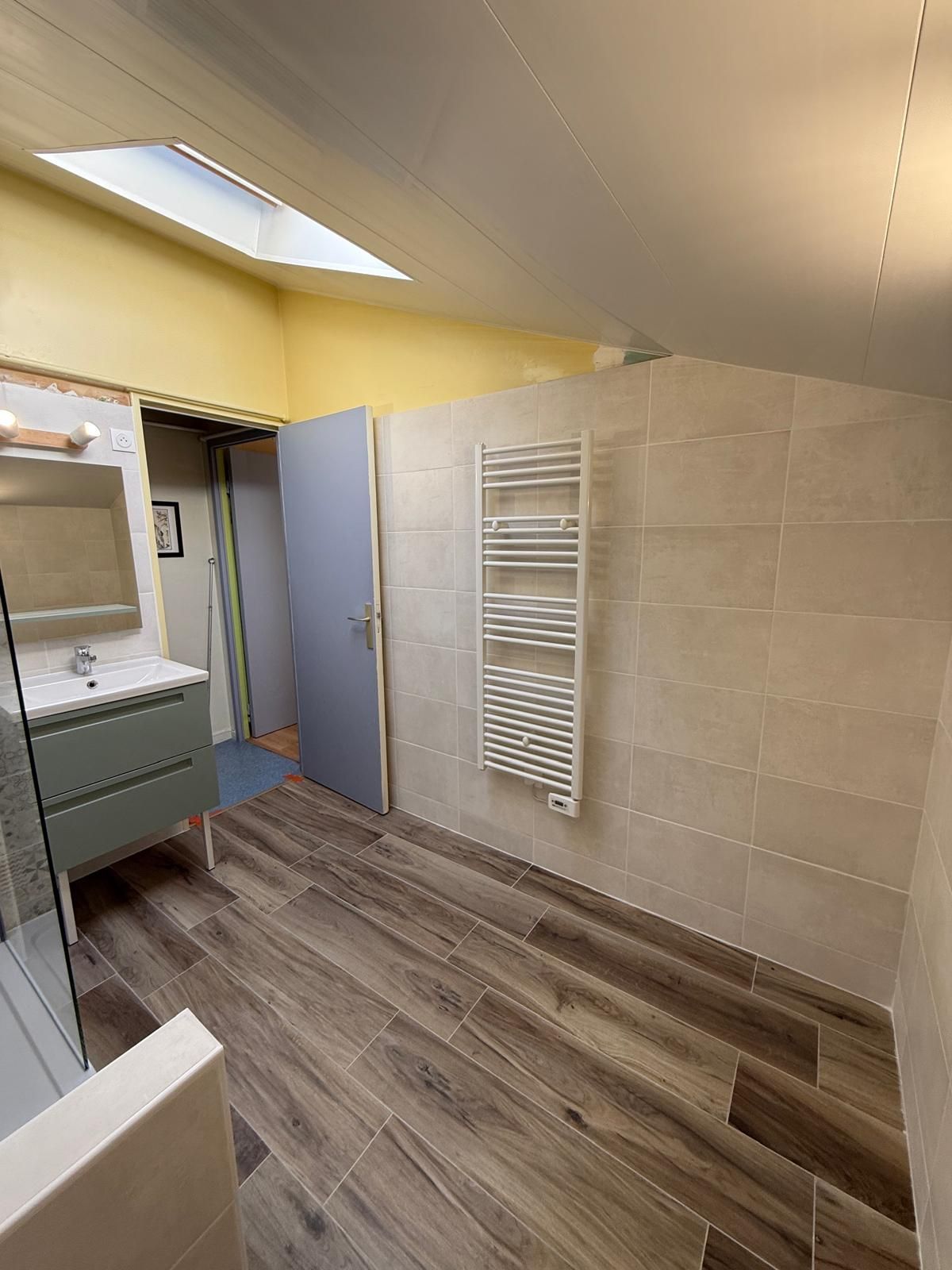 Salle de bain avec parquet flottant, sèche-serviettes et meuble