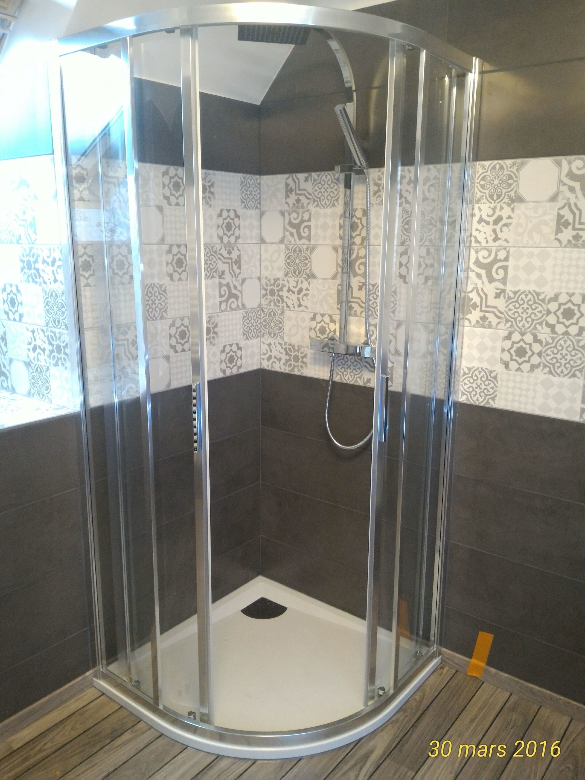 Cabine de douche dans une salle d'eau avec un parquet flottant