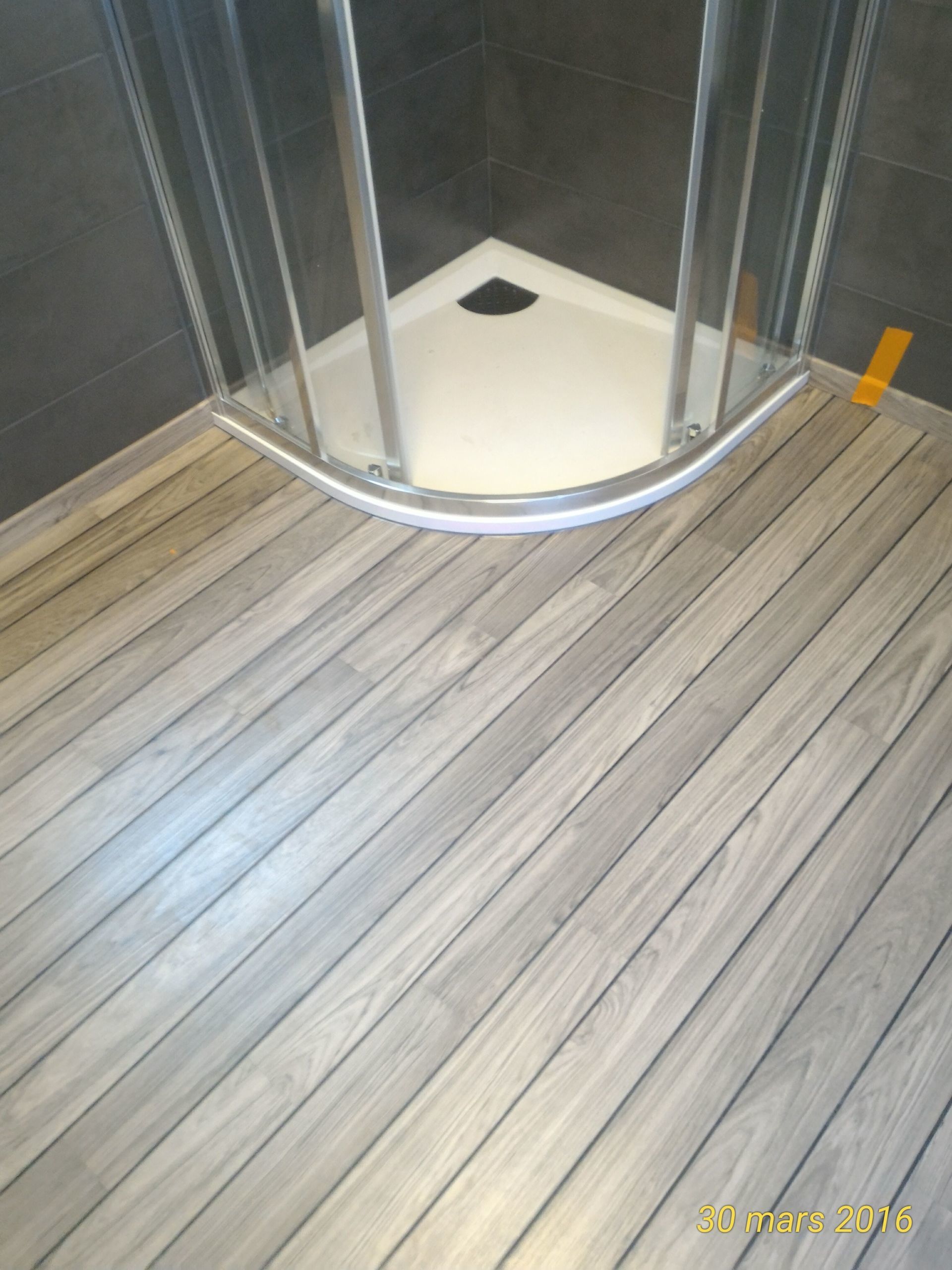 Parquet flottant coupée en angle alignée sur la cabine de douche