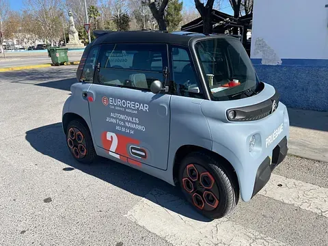 Un pequeño automóvil eléctrico Citroën Ami de color gris, con la marca 