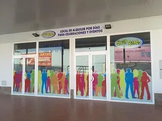 Una tienda con marcos blancos y grandes ventanales. Siluetas coloridas de personas decoran los cristales. El letrero superior dice